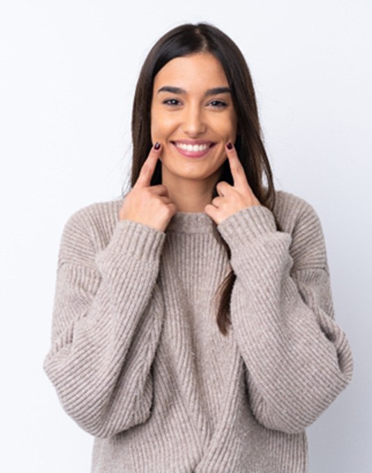 a woman in Cherry Hill pointing at her smile