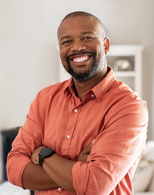 man smiling in orange shirt