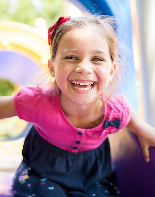 little girl smiling on playground