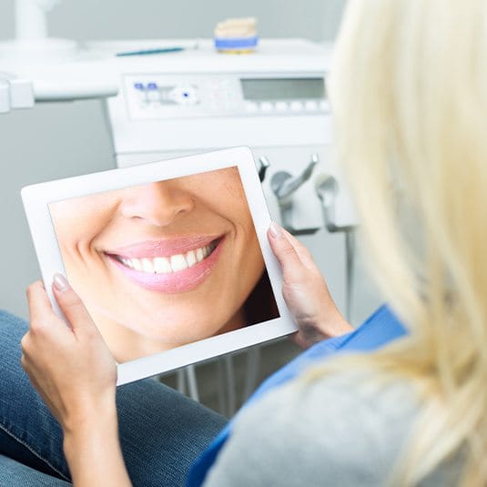 woman looking at smile on tablet