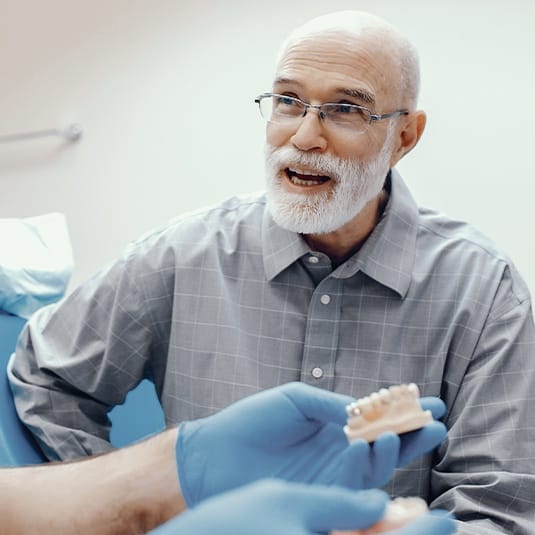 man talking to dentist about dentures