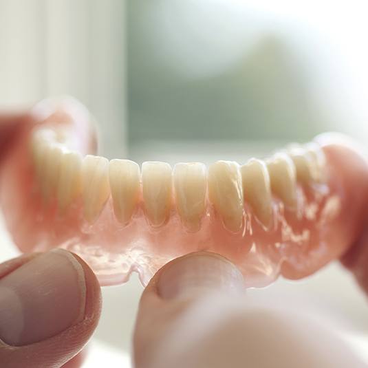 hand holding bottom denture