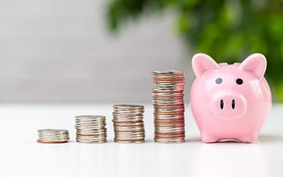 Pile of coins next to a piggy bank