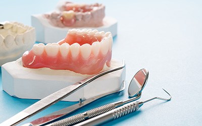 A closeup of various dentures against a blue background