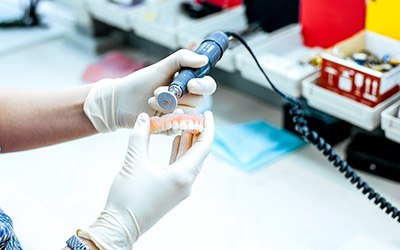 A dental technician working on a denture