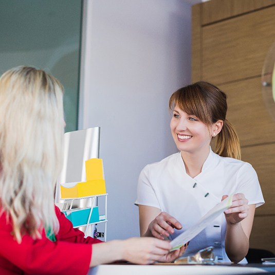 dental team member explaining the cost of dental implants to a patient 