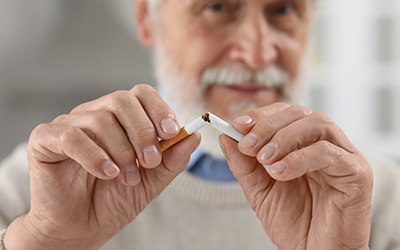 Closeup of man breaking cigarette