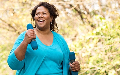 Smiling woman walking with weights