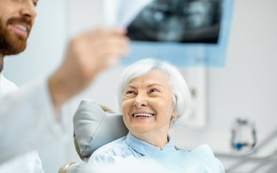 a patient smiling after receiving her dental implants