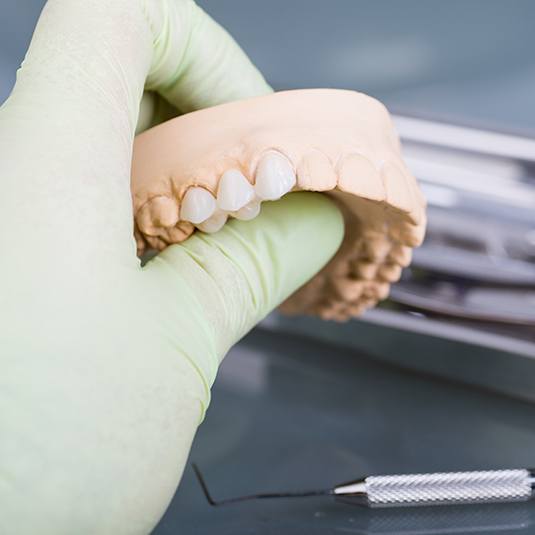 hand holding dental bridge mockup