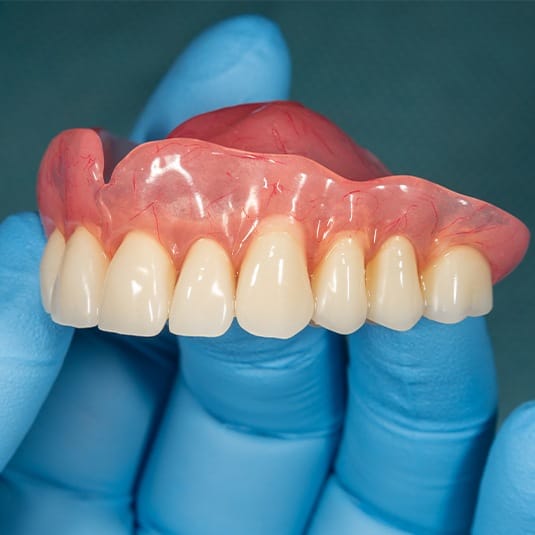 hand holding top denture