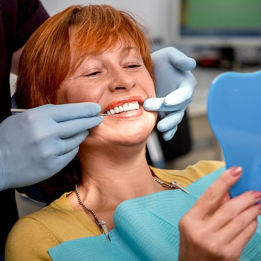 woman looking at smile in mirror