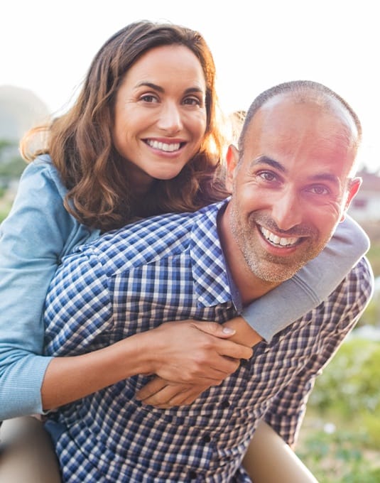 man giving wife piggy back ride