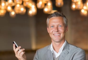 man smiling holding cell phone