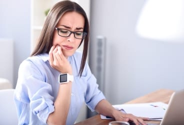 woman holding jaw in pain