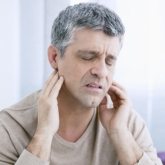 man in severe TMJ pain