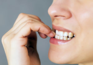 woman with anxiety biting nails