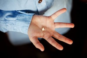 knocked-out permanent tooth held in outstretched palm