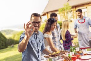 Man with dentures in Cherry Hill enjoying BBQ food