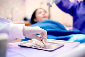 Dentist holding forceps with patient blurry in background